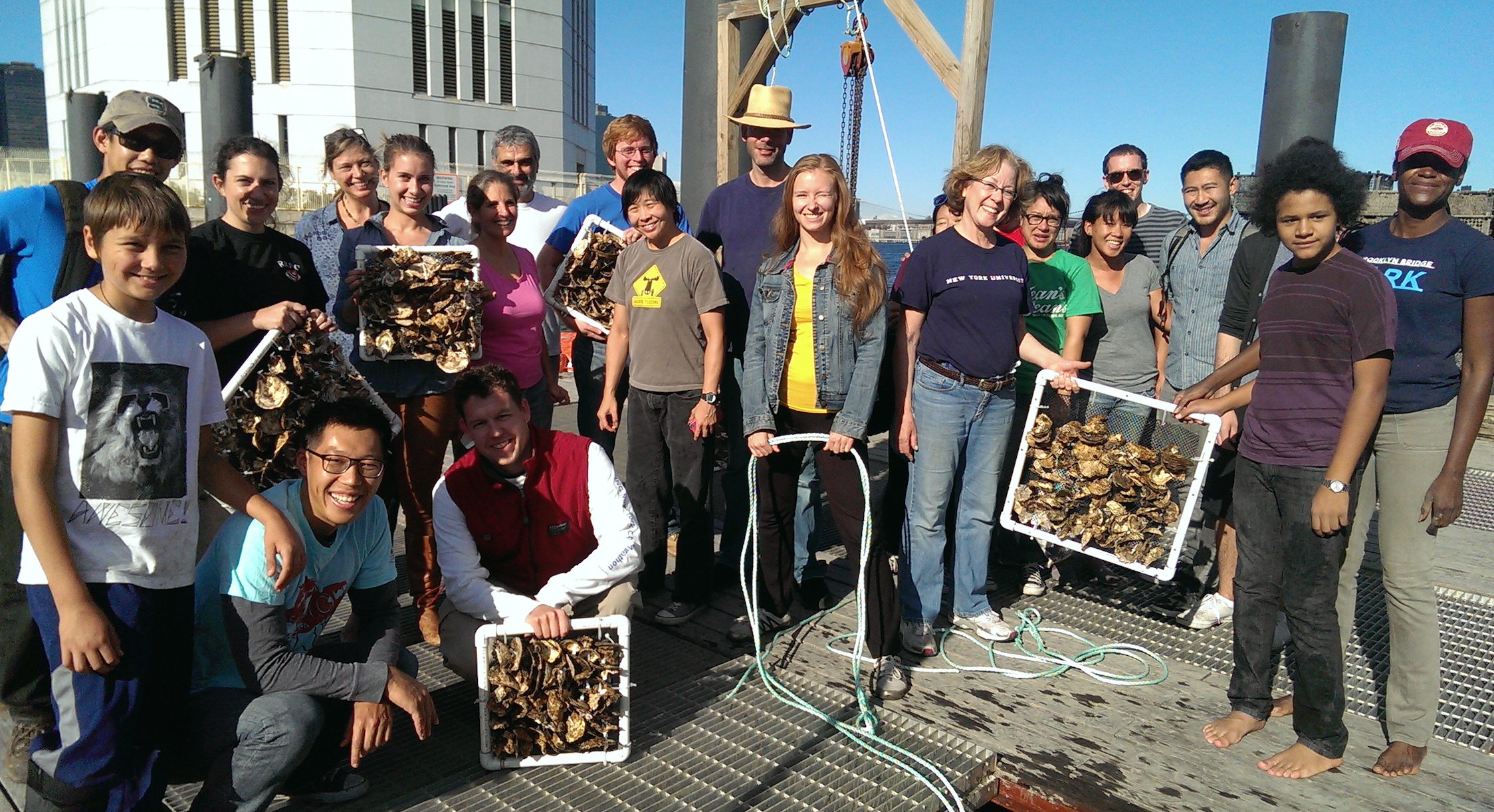 Volunteers posing with oysters in net boxes.